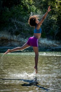 Femme qui danse dehors avec de l'eau.